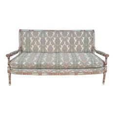 an ornately decorated couch with pink and blue upholstered fabric on the back