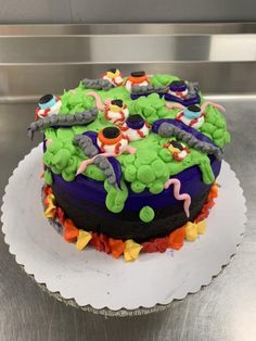 a decorated cake sitting on top of a white plate in front of a metal counter