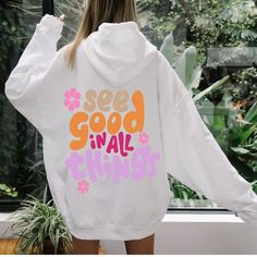 a woman wearing a white hoodie that says see good in all things