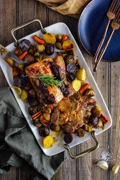 a white plate topped with meat and veggies on top of a wooden table