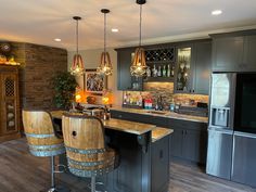 a kitchen with two stools next to a bar