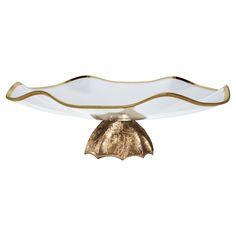 a gold and white glass bowl on a stand