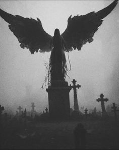 an angel statue surrounded by tombstones and crosses