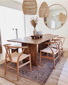 a dining room table with four chairs and a rug on the floor in front of it