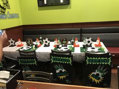 a table set up with soccer themed decorations