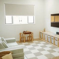 a living room filled with furniture and a flat screen tv mounted on the wall above it