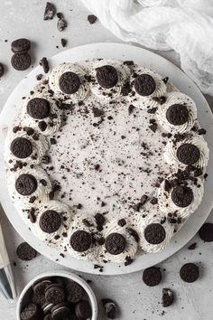 an oreo cookie cake on a white plate with chocolate chips around it and a spoon