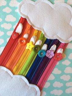 there are many buttons attached to the zippers on this rainbow - themed piece of fabric