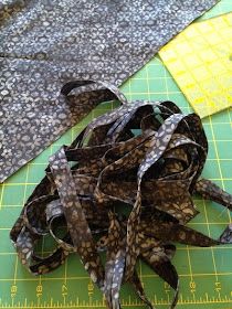 a pile of fabric sitting on top of a green cutting board next to a ruler