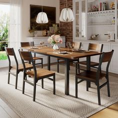 a dining room table and chairs in front of a brick wall with open shelving