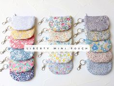 six liberty mini pouch keychains in various colors and patterns are shown on a white background