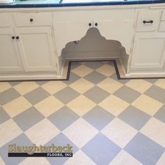 a kitchen with checkered floor and white cabinets