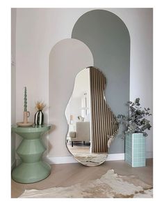 a mirror sitting on top of a wooden floor next to a table