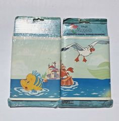 two children's lunch bags with the same cartoon character on them, one is yellow and the other is blue