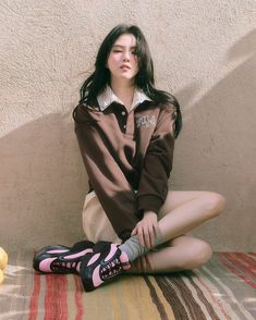 a woman sitting on the ground with her legs crossed