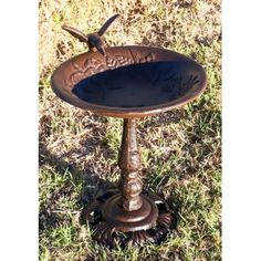 an old fashioned bird bath in the grass