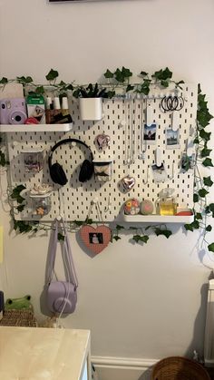 a wall mounted shelf with headphones and other items hanging on it's sides