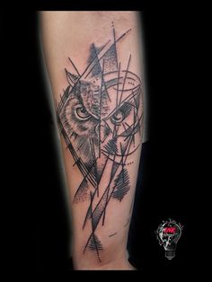 a black and white tattoo with an owl on it's arm, surrounded by geometric shapes