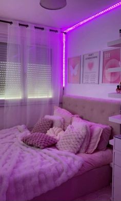 a bedroom with purple lighting and pink bedding