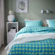 a bed with blue and green comforters in a bedroom