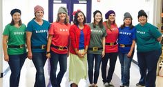 a group of women standing next to each other in front of a door wearing different colored shirts