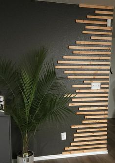 a room with a plant in it and some wood slats on the wall