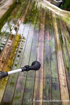 an umbrella that is on the side of a wooden deck with water coming from it