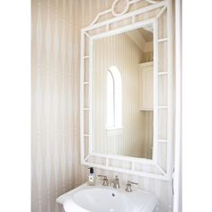 a white sink sitting under a mirror in a bathroom