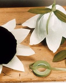 some paper flowers and scissors on a wooden table