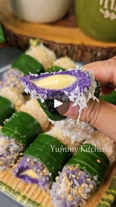 someone is holding some kind of purple and green food in their hand while they are preparing to eat it