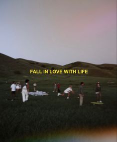 a group of people standing on top of a lush green field next to a rainbow