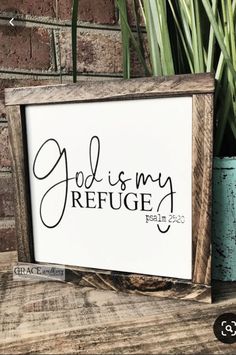 a sign that says god is my refuge on it next to a potted plant