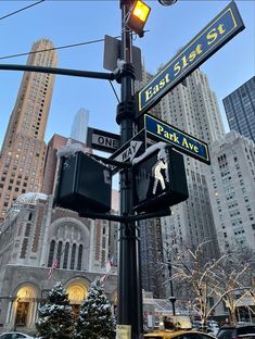 street signs and traffic lights on a pole in the city