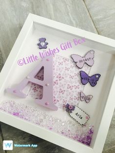 there is a white box with purple letters and butterflies on the inside, along with other items