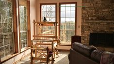 a living room filled with furniture and a fire place in front of two large windows