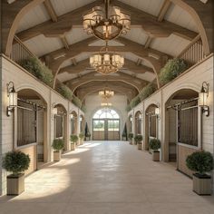 the inside of a large building with lots of windows and potted plants on either side