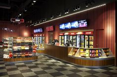 the inside of a grocery store with checkered flooring and food display cases in it