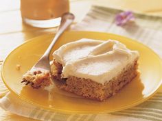 a piece of cake on a yellow plate with a knife and fork next to it