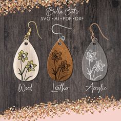 three wooden tear shaped earrings with flowers on them and the words, wood leather earring