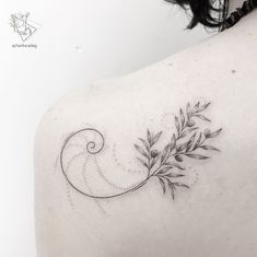 a woman's back shoulder with an artistically designed tattoo on her left shoulder