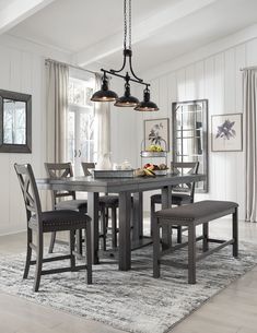 a dining room table with four chairs and a bench