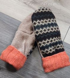 two mittens sitting on top of a wooden floor