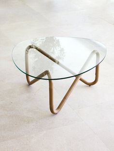 a glass table with metal legs and a circular glass top