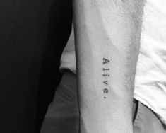 a man's arm with the word alive tattooed on it