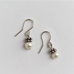 Small silver earrings with an asian silver ornament and fresh water pearls. You can buy the pair or a single earring. Classic Silver Pearl Earrings For Everyday, Classic Silver Pearl Charm Earrings, Silver Sterling Pearl Earrings With Pearl Charm, Classic Silver Pearl Earrings With Charm, Dainty Silver Pearl Earrings For Pierced Ears, Dainty Pearl White Earrings, Everyday Hypoallergenic White Gold Pearl Earrings, Nickel-free Pearl Earrings As Gift, Nickel Free Classic Dangle Pearl Earrings