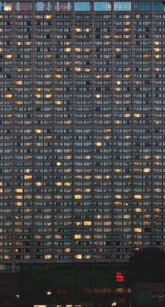 a tall building with lots of windows lit up at night