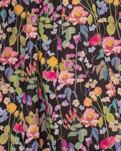 the back of a woman's pants with colorful flowers on it and green leaves