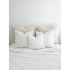 a white bed topped with lots of pillows