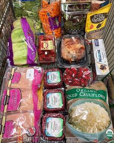 a grocery cart filled with food and vegetables