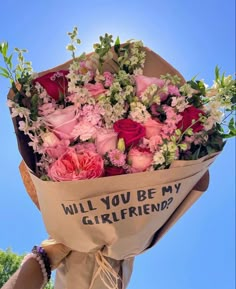 a bouquet of flowers wrapped in brown paper with the words will you be my girlfriend?